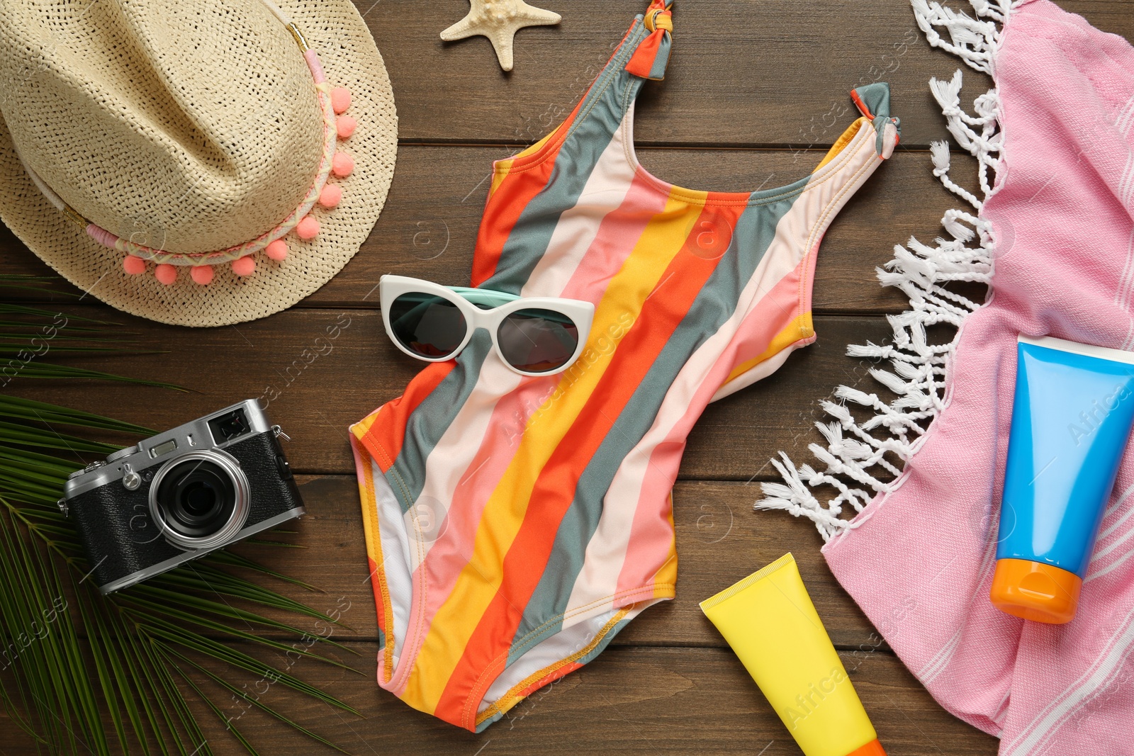 Photo of Different beach objects on wooden background, flat lay