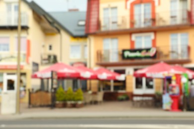 Photo of Blurred view of outdoor cafe with umbrellas