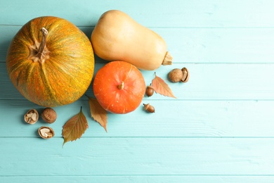 Photo of Different pumpkins on wooden background, flat lay composition with space for text. Autumn holidays