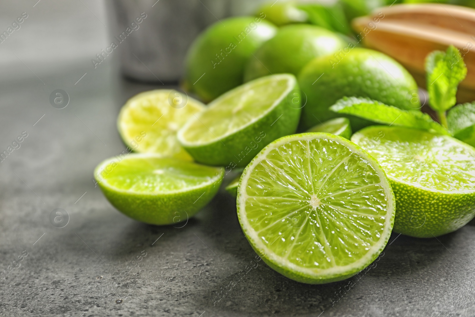 Photo of Ripe limes on grey background. Refreshing beverage recipe