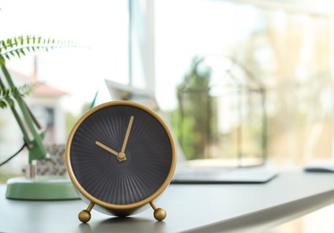 Analog alarm clock on table in office. Time to work