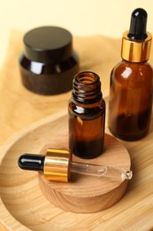 Photo of Composition with bottles of cosmetic serum on beige background, closeup