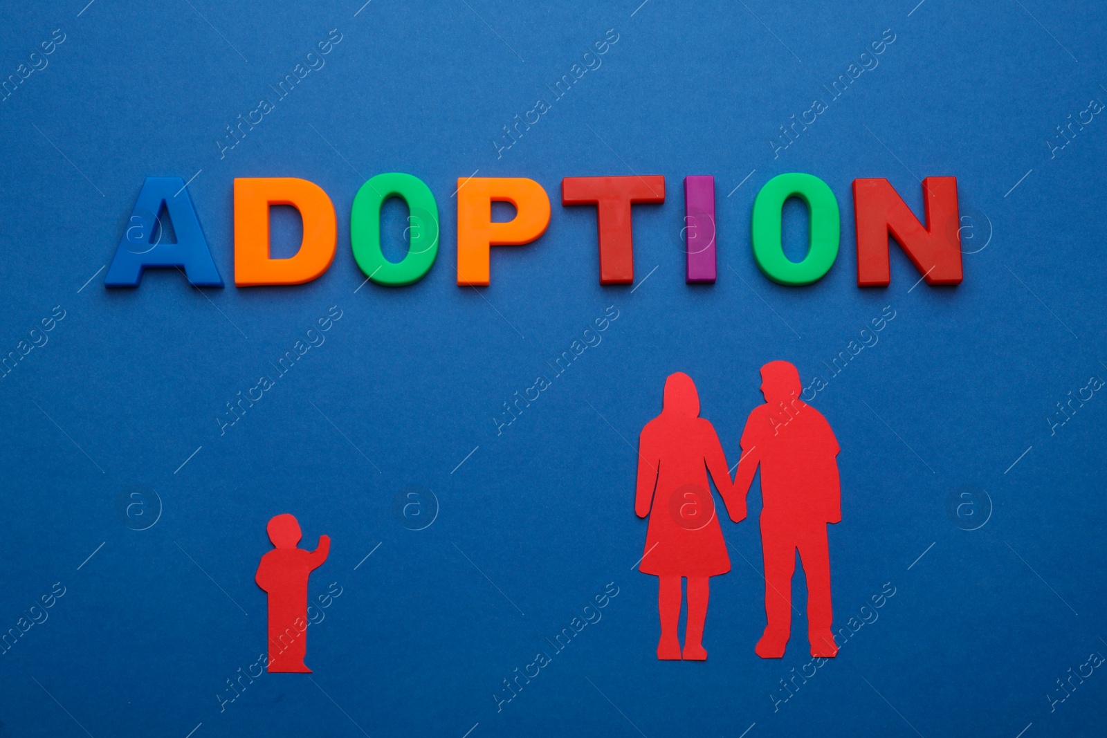 Photo of Figures of parents with child and word Adoption on blue background, flat lay