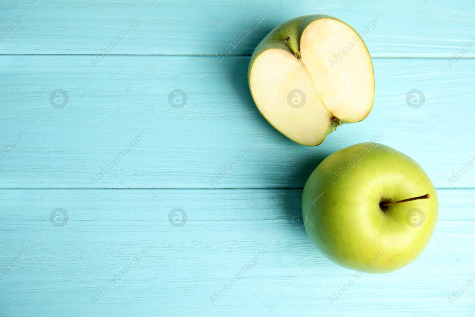 Photo of Flat lay composition of fresh ripe green apples on blue wooden table, space for text