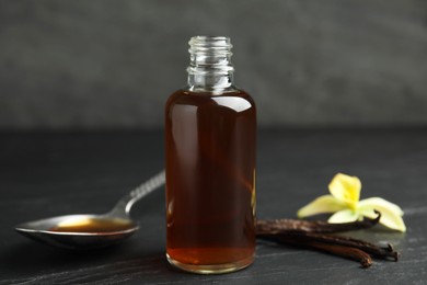 Photo of Aromatic homemade vanilla extract on black table