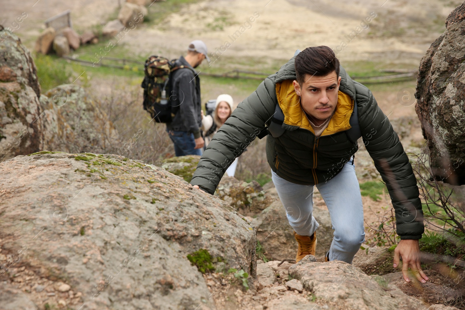 Photo of Group of hikers with backpacks climbing up mountains