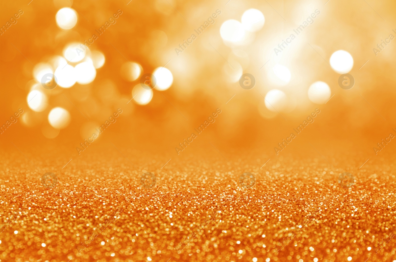 Image of Shiny orange glitter and blurred lights on background. Bokeh effect