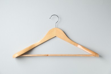 Photo of Empty wooden hanger on light grey background, top view