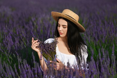 Beautiful young woman with bouquet in lavender field