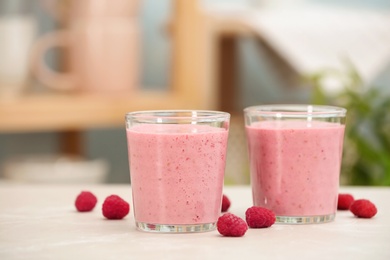 Photo of Delicious smoothie in glasses and raspberries  on table