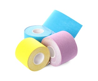 Photo of Many bright kinesio tape in rolls on white background