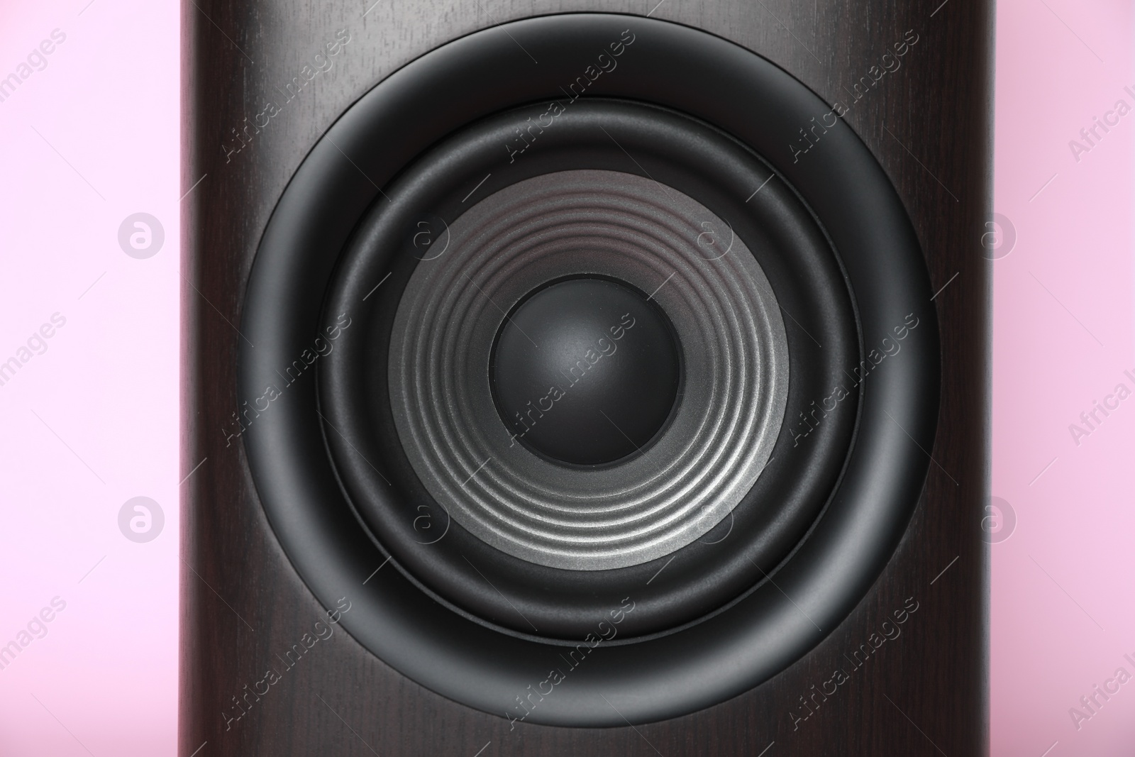 Photo of One wooden sound speaker on pink background, closeup