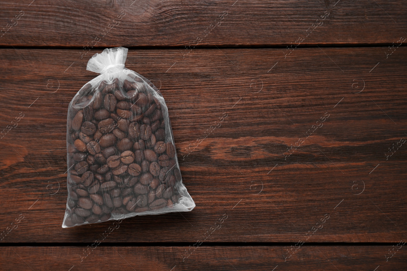 Photo of Scented sachet with coffee beans on wooden table, top view. Space for text