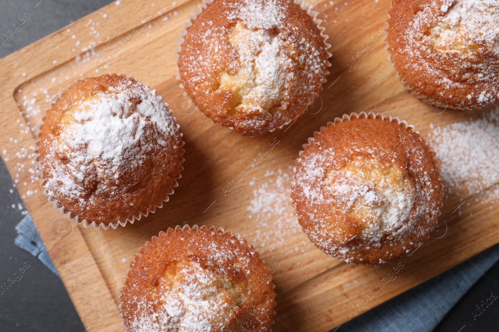 Photo of Delicious sweet muffins on black table, top view