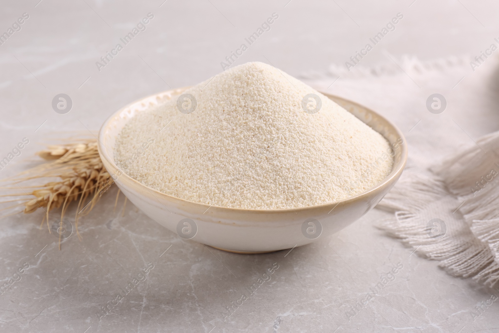 Photo of Uncooked organic semolina and spikelets on light table