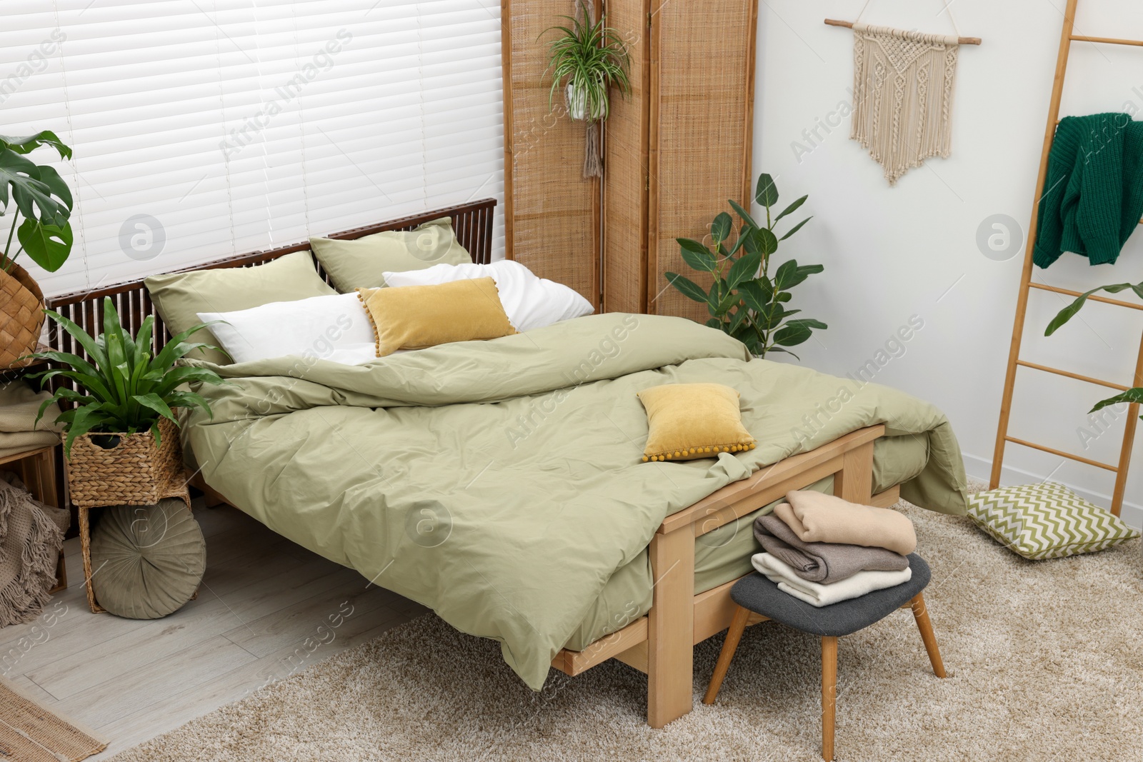 Photo of Comfortable bed and beautiful green houseplants in bedroom