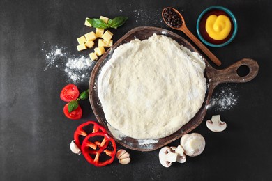 Photo of Pizza dough and products on dark table, flat lay