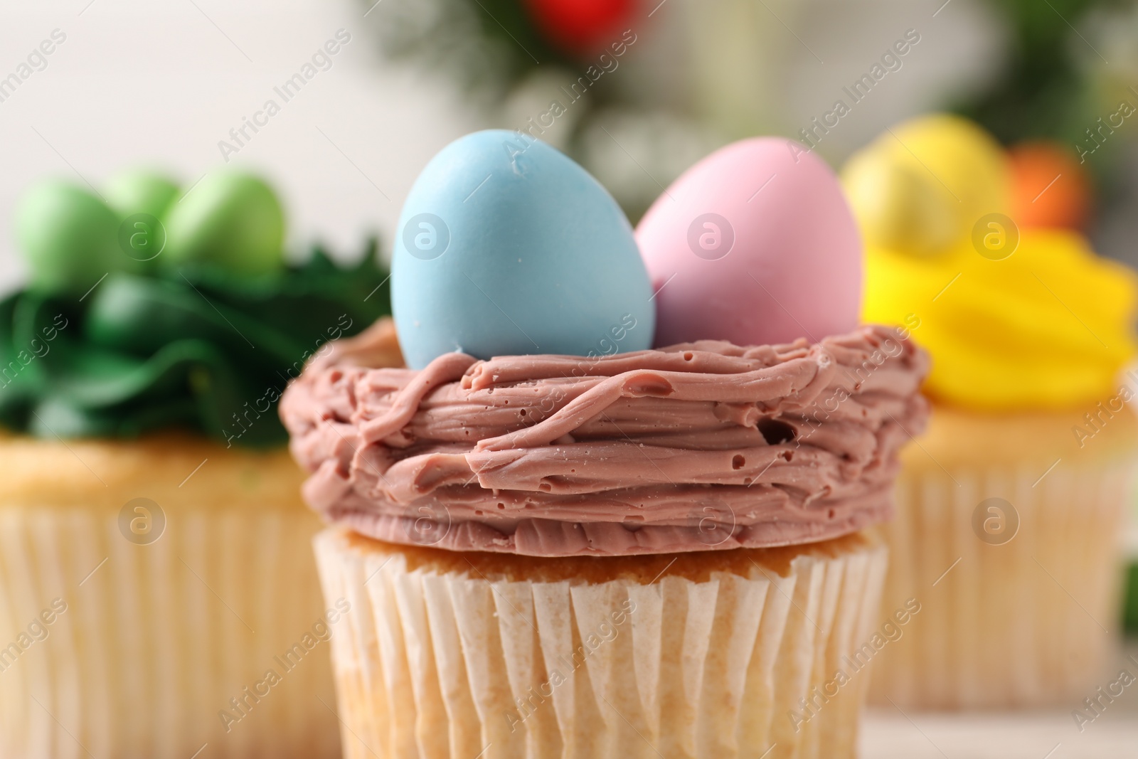 Photo of Tasty decorated Easter cupcakes on table, closeup