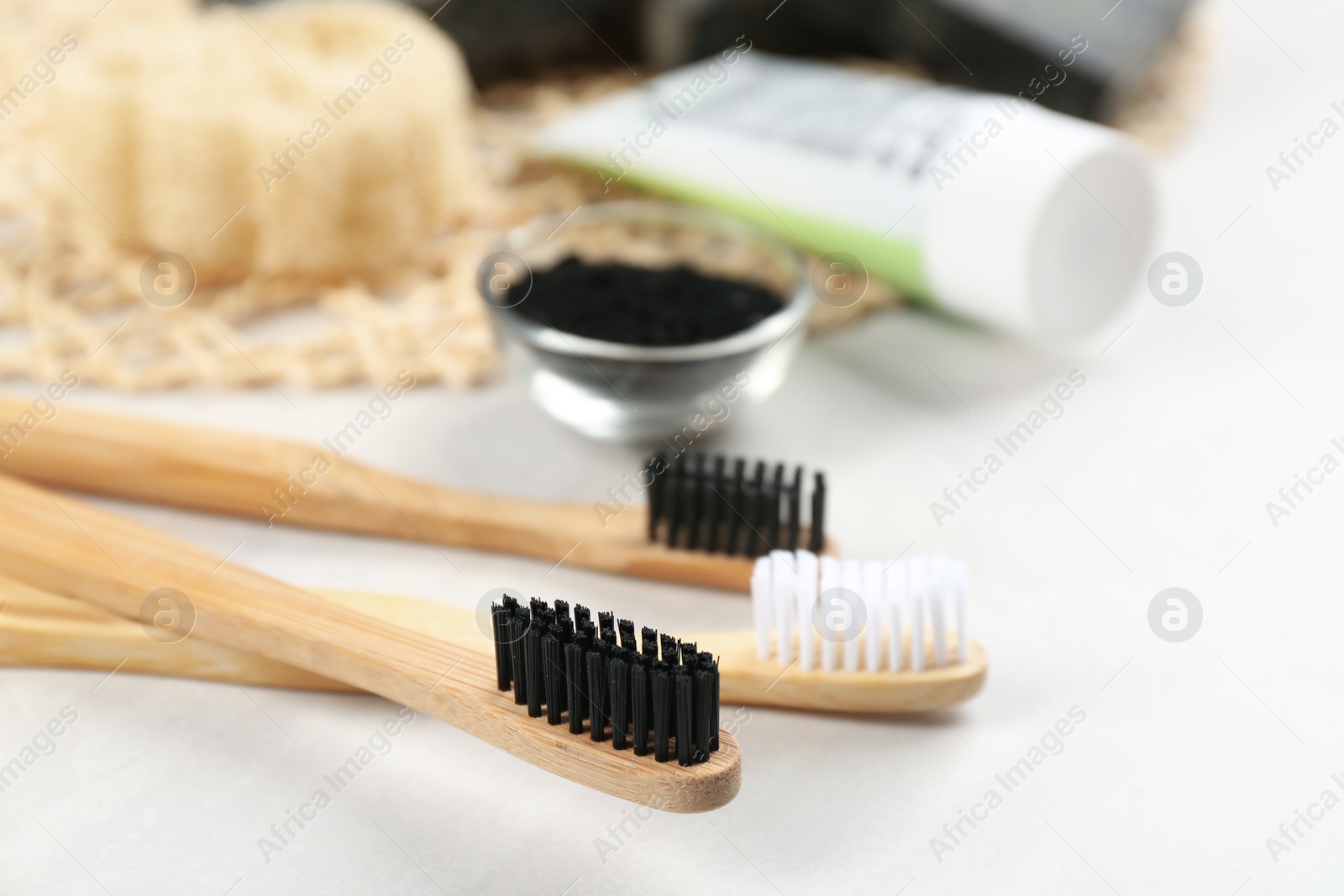 Photo of Bamboo toothbrushes on white table, closeup. Space for text