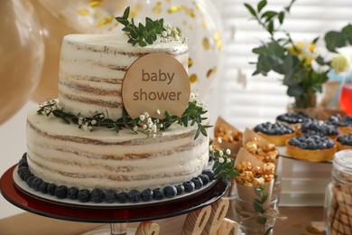 Beautiful cake and delicious party treats on wooden table indoors