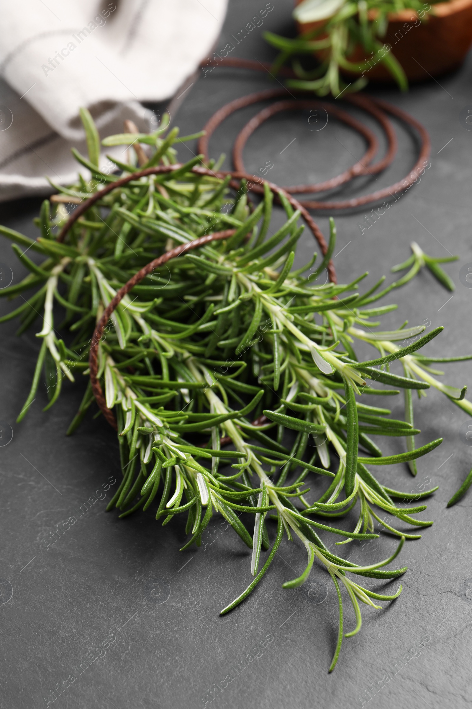Photo of Sprigs of fresh rosemary with twine on black table, closeup