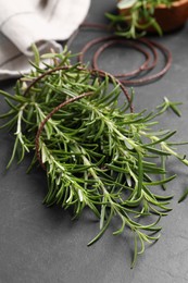 Photo of Sprigsfresh rosemary with twine on black table, closeup