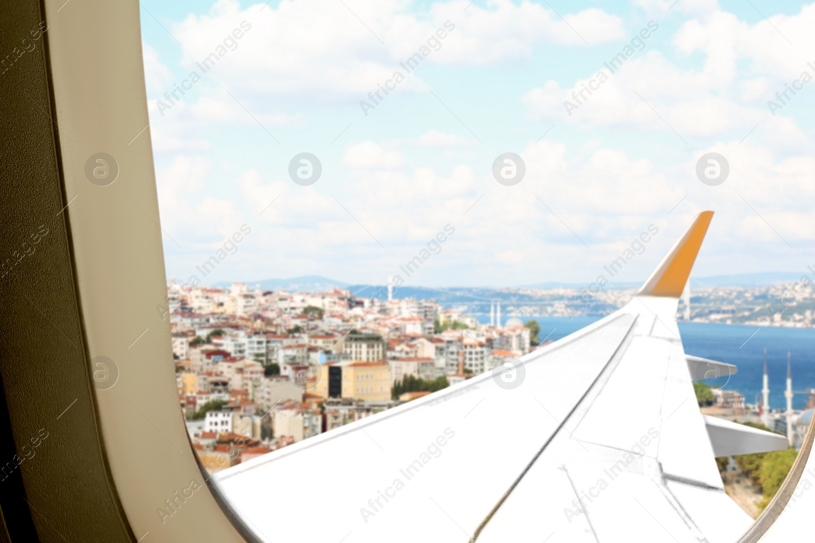 Image of Beautiful city and sea, view through airplane window during flight