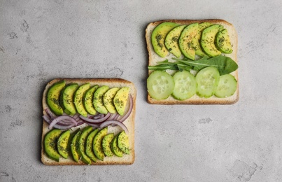 Photo of Tasty avocado toasts on light grey table, flat lay