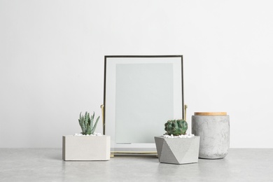 Photo of Blank frame and beautiful succulent plants on table against light background, space for design. Home decor