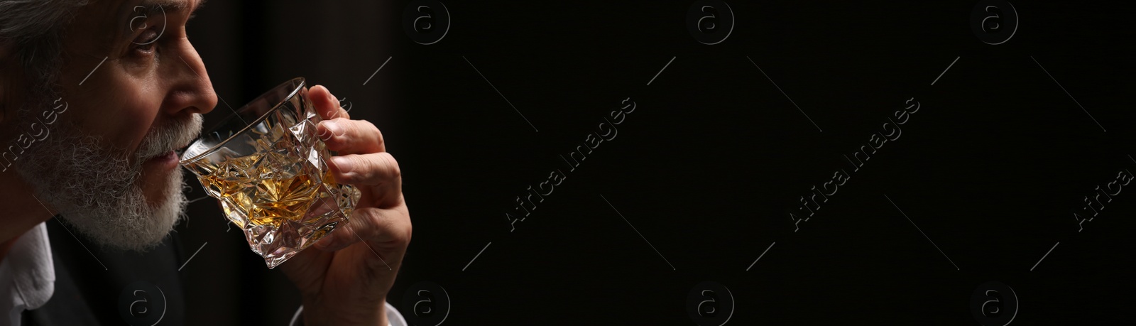 Image of Man drinking whiskey on dark background, space for text. Banner design