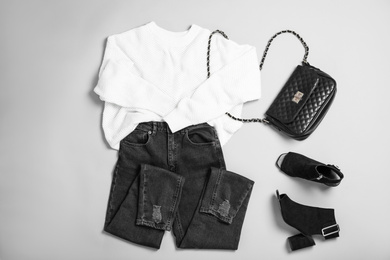 Photo of Stylish outfit with jeans on light grey background, flat lay