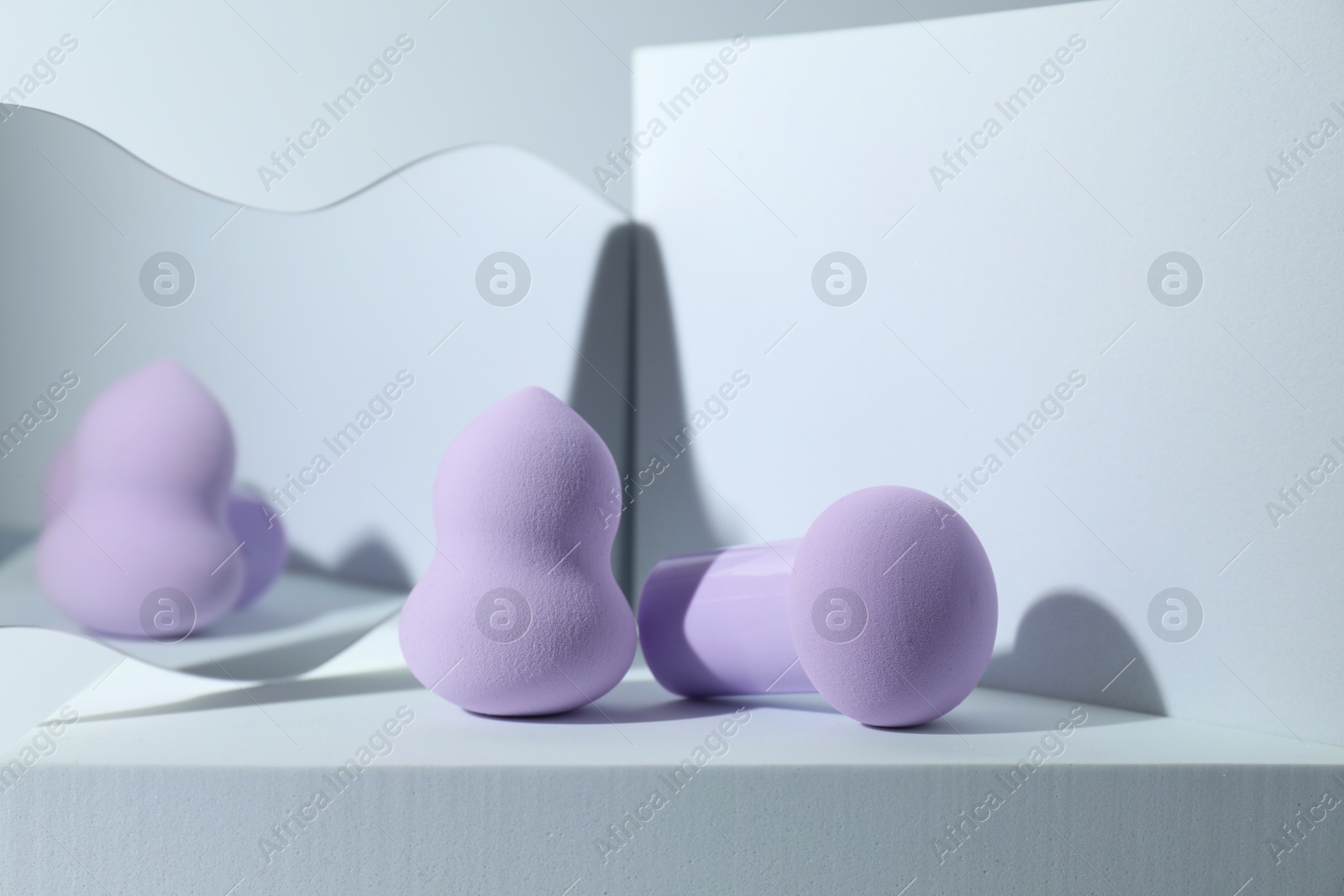 Photo of Stylish presentation of makeup sponges on light grey background