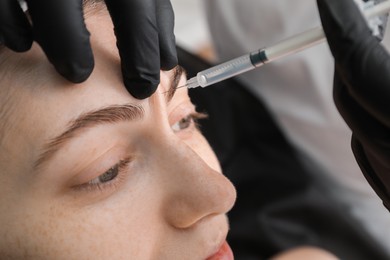 Photo of Cosmetologist giving facial injection to patient, closeup. Cosmetic surgery