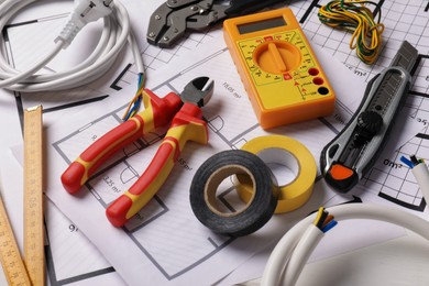 Photo of Different wires and tools on electrical schemes, closeup