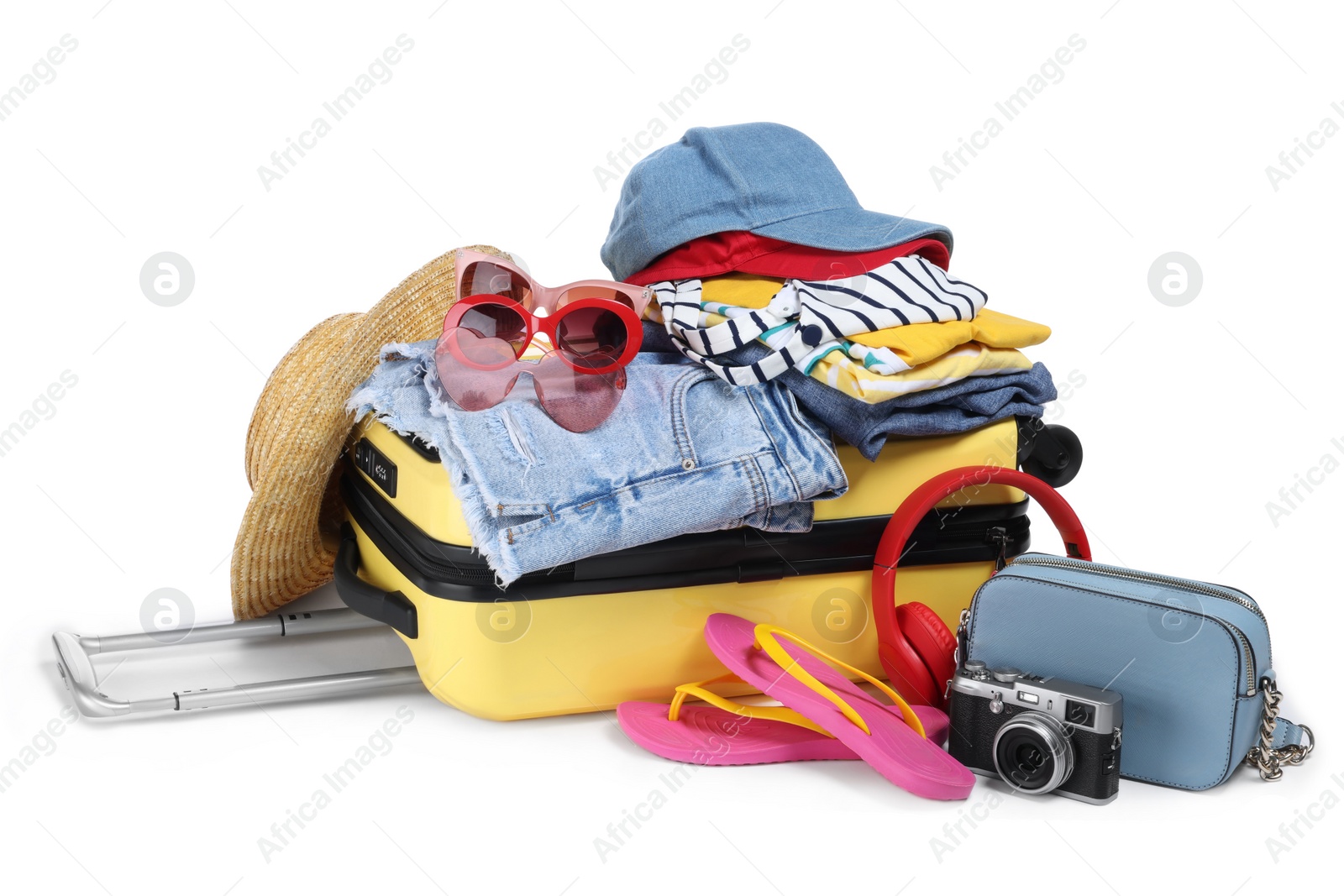 Photo of Open suitcase with clothes, beach accessories and shoes isolated on white. Summer vacation