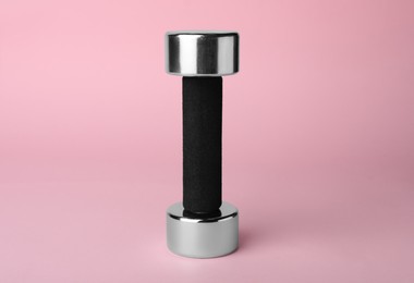 Photo of One metal dumbbell on light pink background