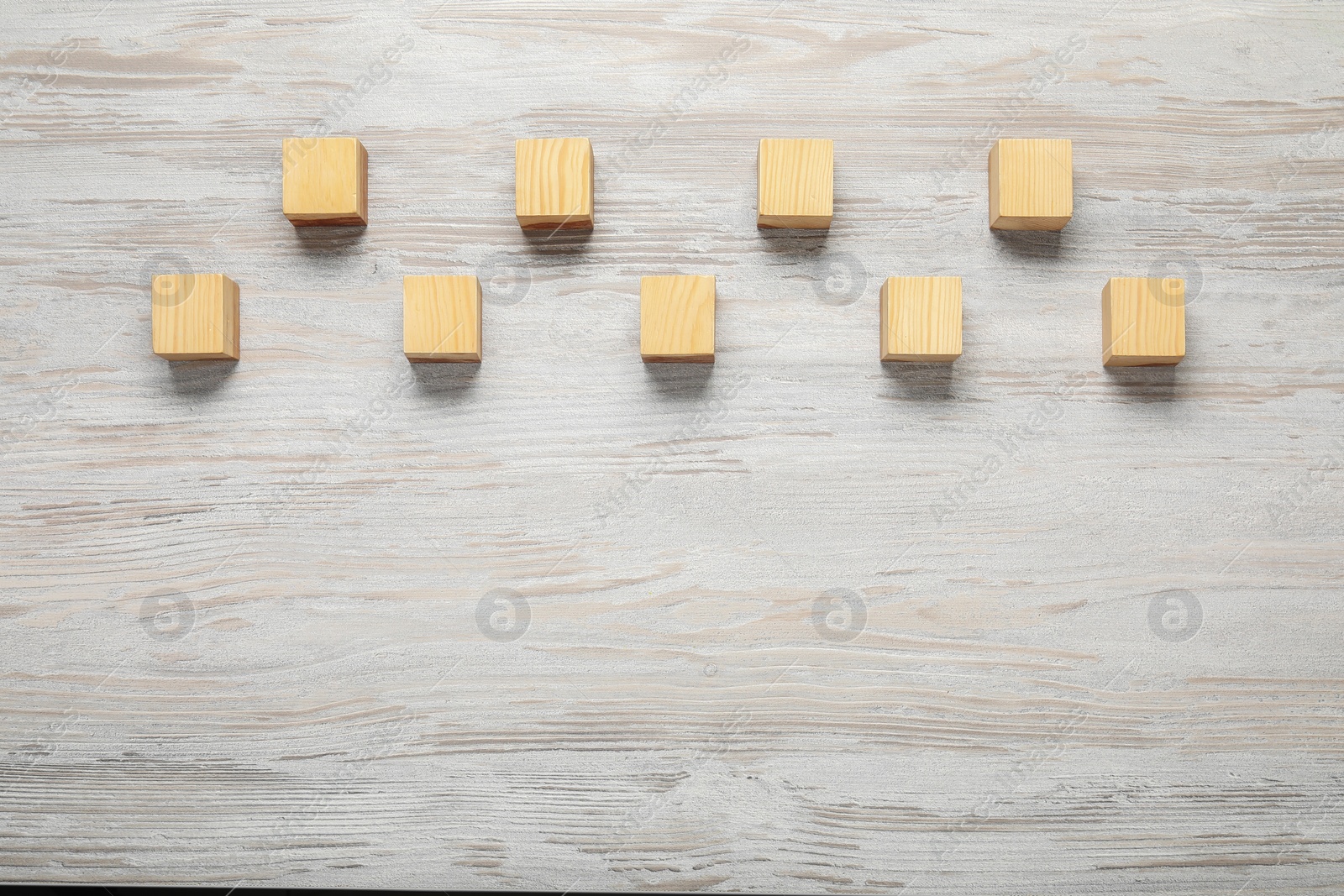 Photo of Blank cubes on white wooden table, flat lay. Space for text