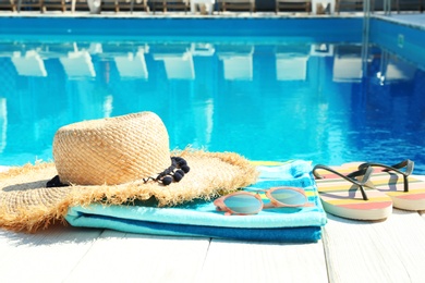 Photo of Beach accessories on wooden deck near swimming pool