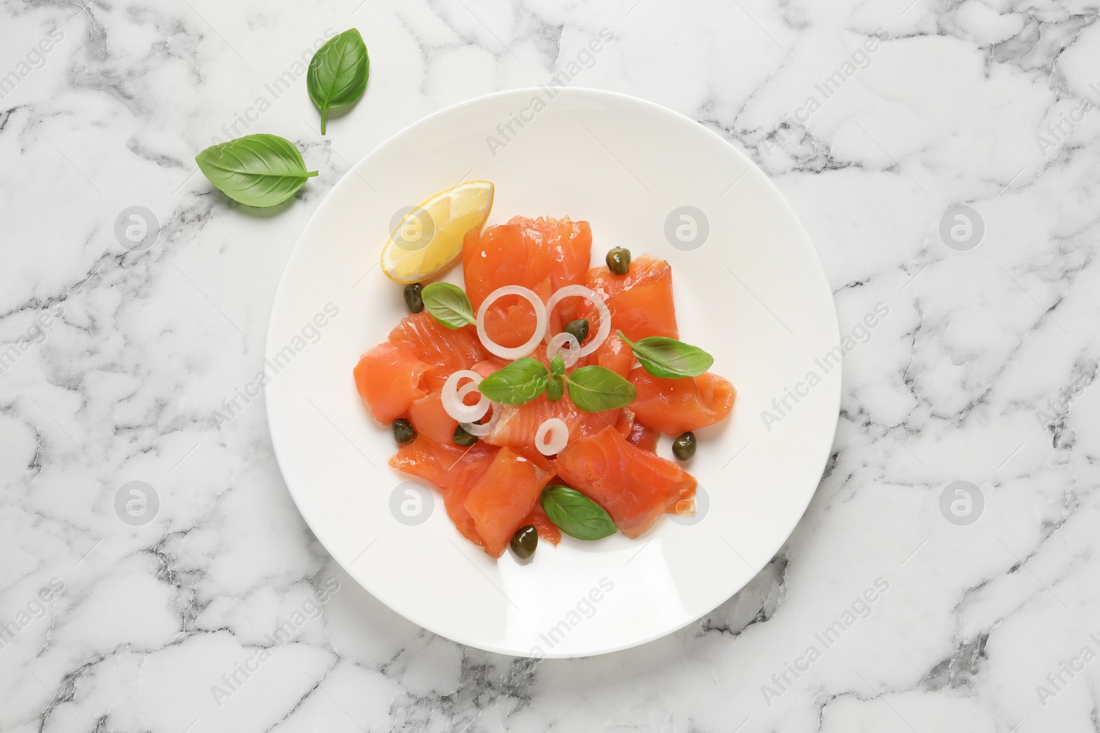 Photo of Delicious salmon carpaccio served on white marble table, flat lay