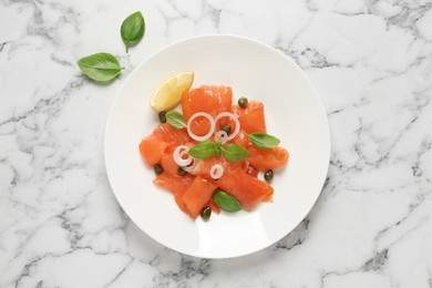 Delicious salmon carpaccio served on white marble table, flat lay