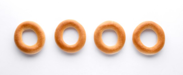 Tasty dry bagels (sushki) on white background, top view