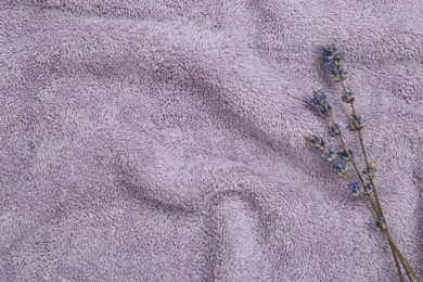 Photo of Lavender flowers on violet terry towel, top view. Space for text