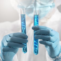 Image of Genetics research. Scientist holding test tubes with liquid and illustrations of DNA structure, closeup