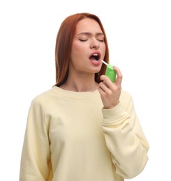Young woman using throat spray on white background