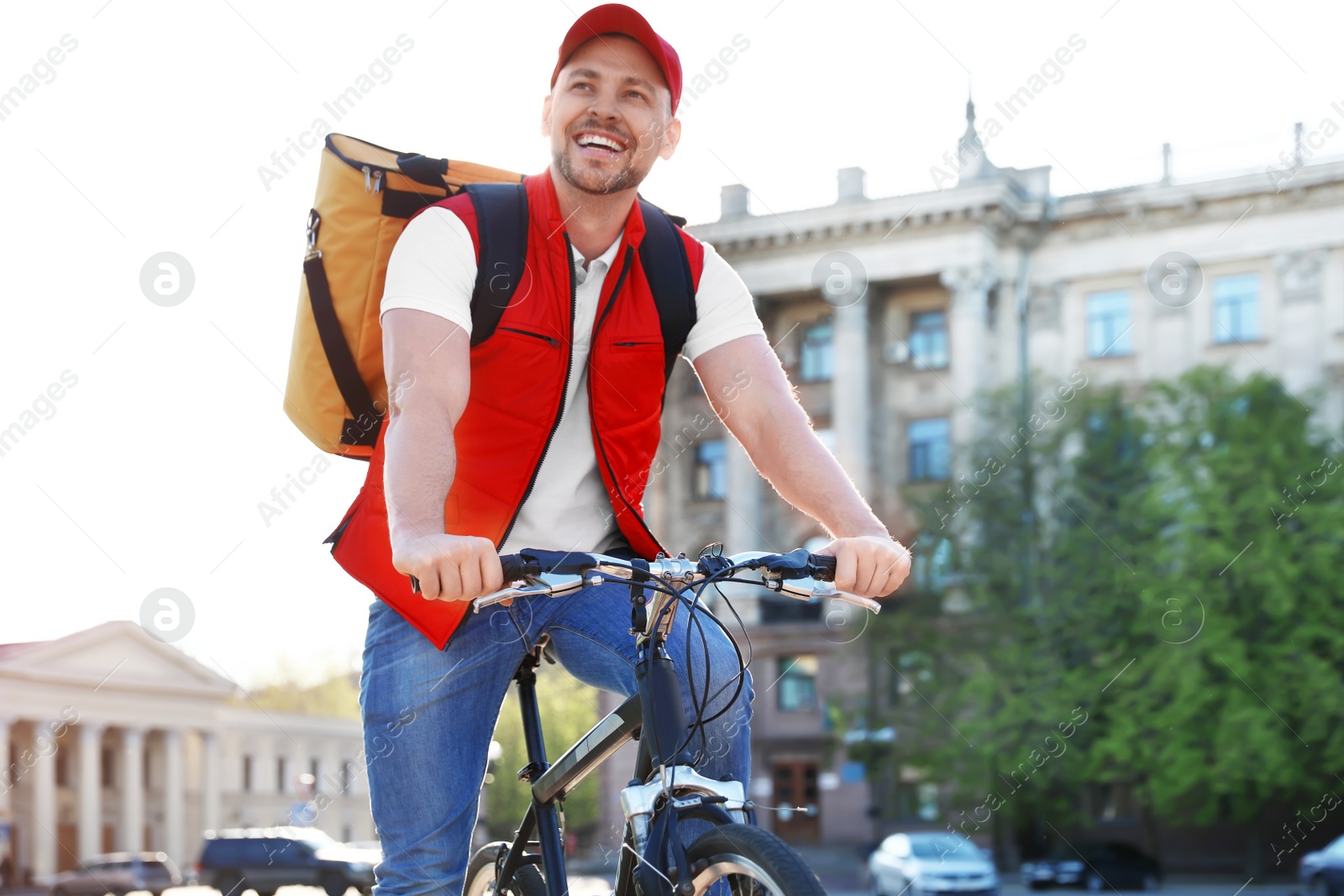 Photo of Male courier on bicycle delivering food in city