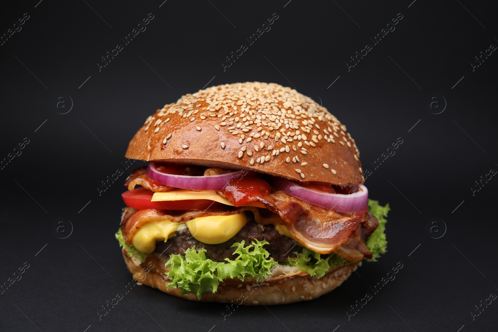Photo of Delicious burger with bacon, patty and vegetables on black background