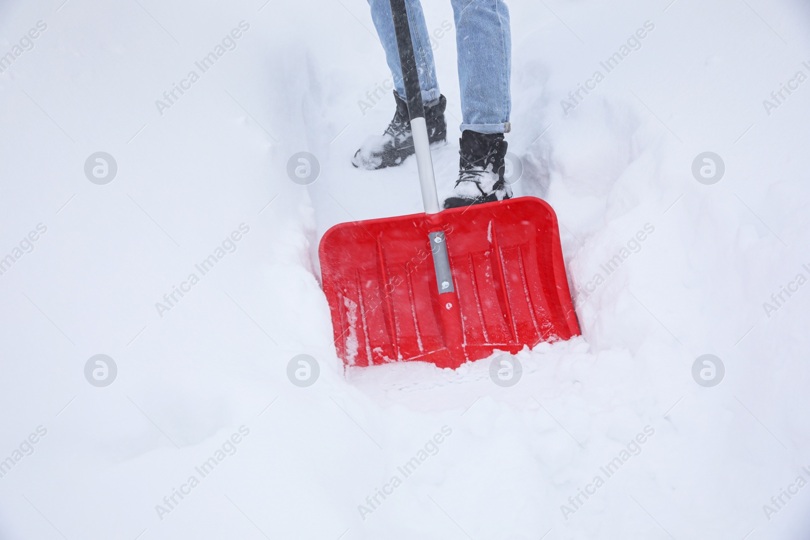 Photo of Man cleaning snow with shovel outdoors, closeup