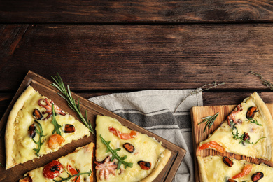 Photo of Pieces of delicious seafood pizza on wooden table, flat lay. Space for text