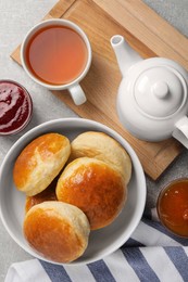 Tasty scones prepared on soda water, jam and tea on grey marble table, flat lay