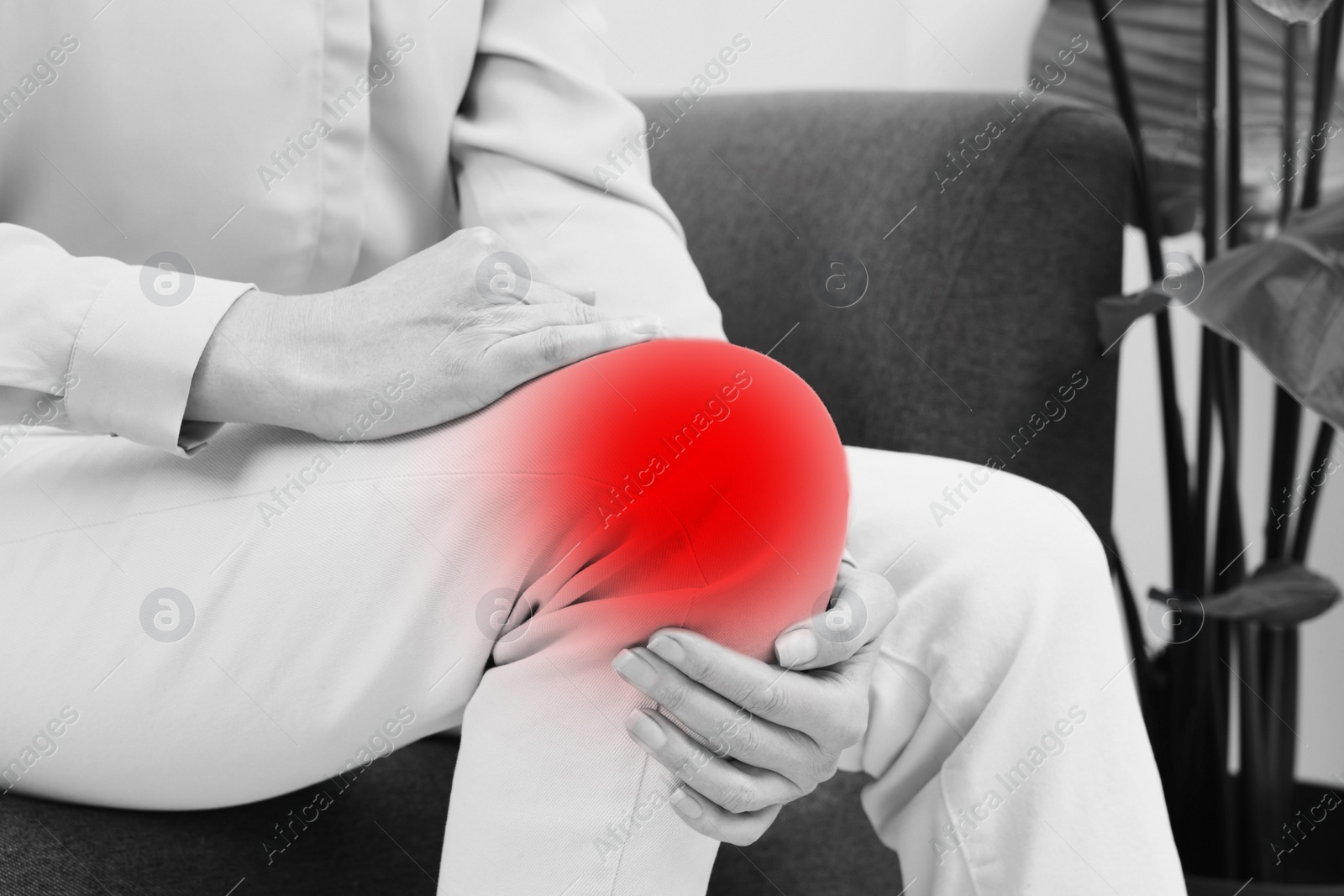 Image of Woman suffering from rheumatism at home, closeup. Black and white effect with red accent in painful area